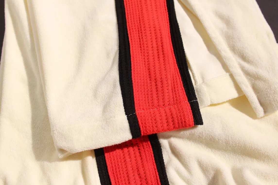 Close-up of a retro Terry tracksuit with an unexpected athletic stripe detail made from thermal knit fabric