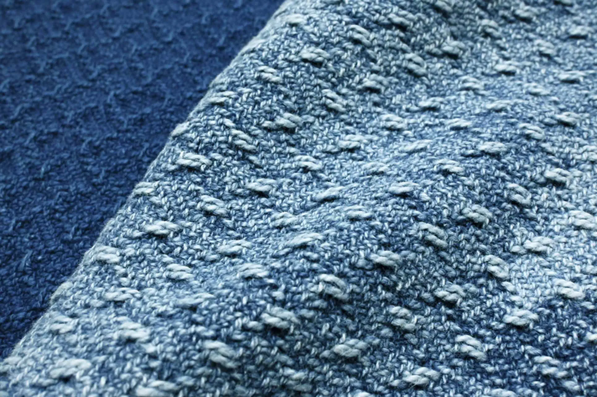 Close-up of 100% cotton dobby fabric dyed with natural indigo and garment washed for a bleached surface effect
