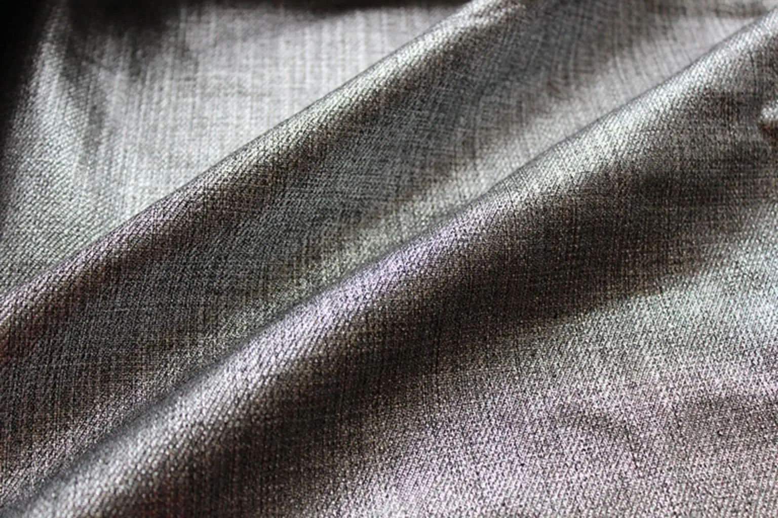 Close-up of denim fabric with a silver polyurethane coating, adding a futuristic element.